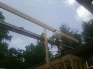 Carpenter setting a ridge beam over a new addition frame — Ice Dam Removal by Roofing Brothers in Verplanck