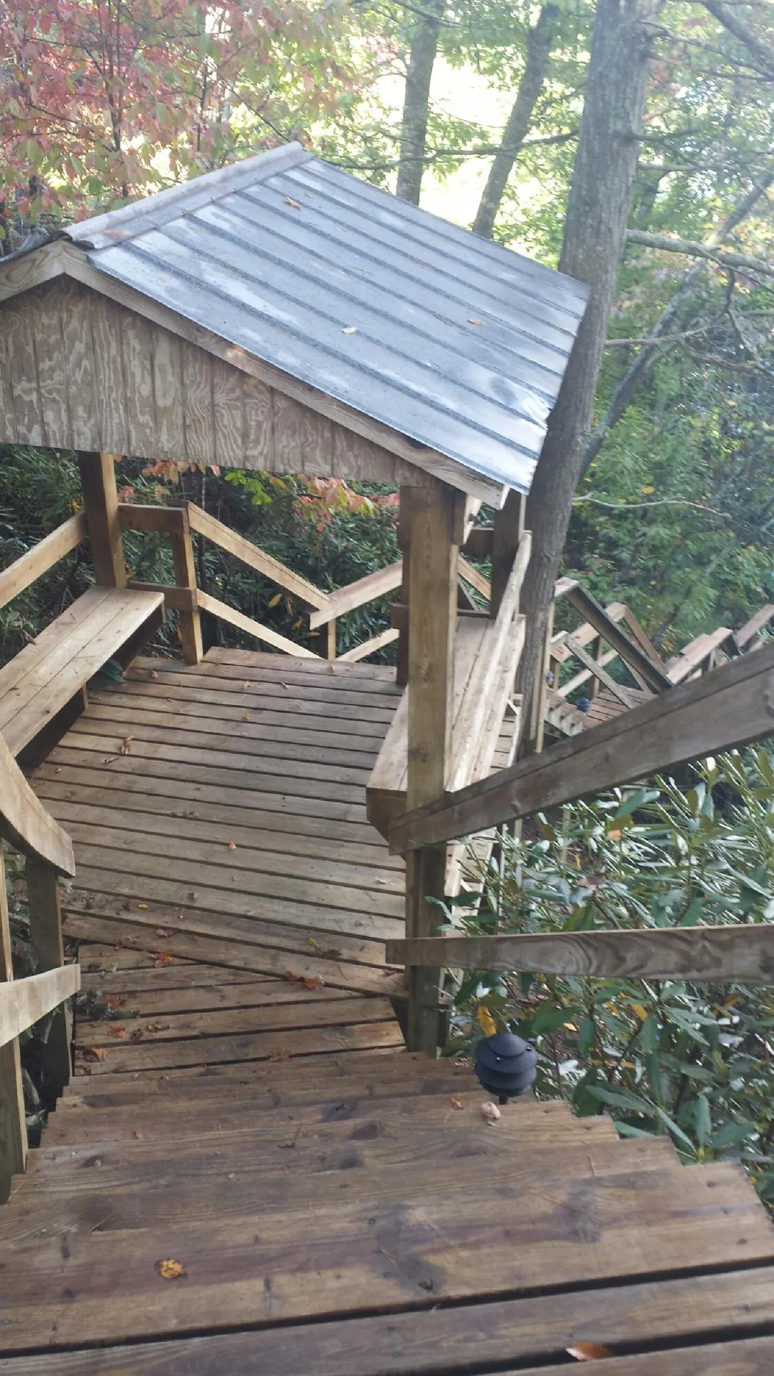 Metal roofed shelter over wooden steps on a wooded walkway — Skylight Repair & Installation work by our crew in Verplanck